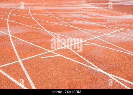 The bright red runway interweaves the straight white trajectory with the curved white trajectory. Stock Photo