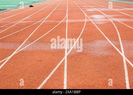 The bright red runway interweaves the straight white trajectory with the curved white trajectory. Stock Photo