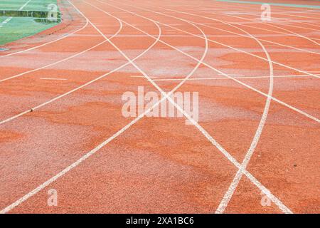 The bright red runway interweaves the straight white trajectory with the curved white trajectory. Stock Photo