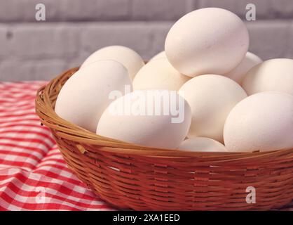 A basket of white eggs on a tablecloth Stock Photo