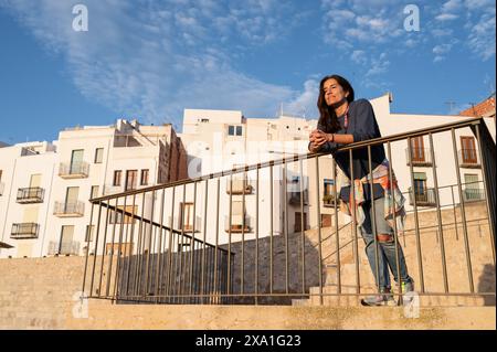 Young woman enjoying the sunset from the city walls of Papa Luna castle in Peñiscola, Castellon, Valencian Community, Spain Stock Photo