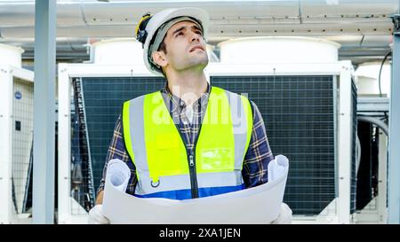 A man working at a construction site, wearing a protective helmet and uniform Stock Photo