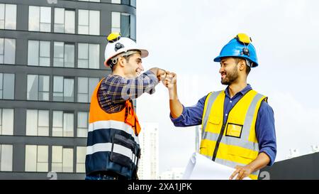 The two engineers shake hands in an urban or industrial setting before construction work. Stock Photo