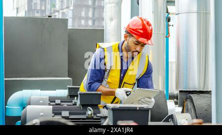 A male worker in a red hard hat conducting maintenance. Stock Photo
