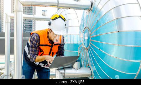 An engineer working on a laptop at a building site. Stock Photo