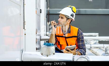 An engineer talking on a walkie-talkie at a construction site. Stock Photo