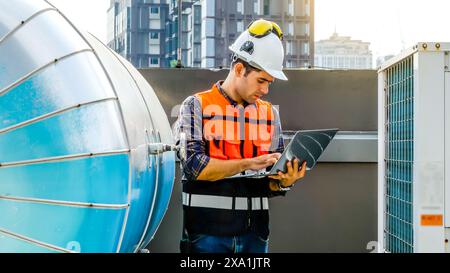 An engineer using a laptop in a construction site. Stock Photo