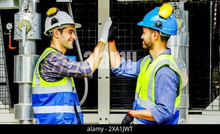 The two construction workers celebrate with a high five on a construction site. Stock Photo