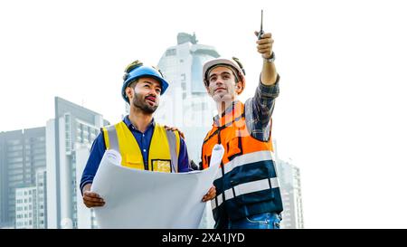 The engineers discussing plans on building a roof, one pointing. Stock Photo