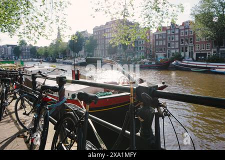 Close-up of a bicycle leaning against the fence in front of the canal Stock Photo