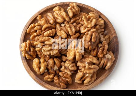 A plate of walnuts is on a wooden table. The walnuts are spread out and appear to be fresh Stock Photo