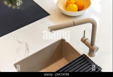 Close-up of modern faucet and sink on bright marble counter top Stock Photo