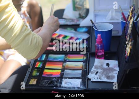 A variety of paints and art supplies scattered on a table Stock Photo