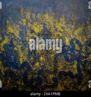 A grunge yellow paint splattered on a dirty wall surface. Stock Photo