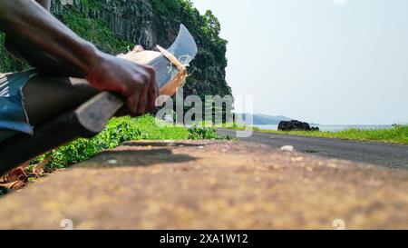 View of an African man with a machete cutting a coconut.Sao Tome,Africa Stock Photo