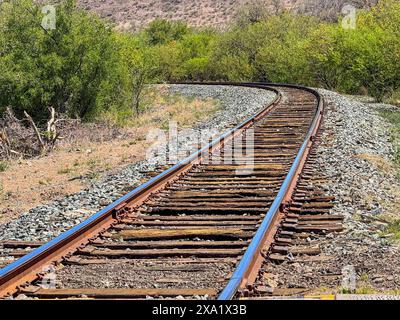 Train tracks and sleepers in the mountains in the Turicachi community and ejido Km 47 located between Nacozari and Esqueda municipality of Fronteras in Sonora Mexico. PIRA ceremonial act of Apache training, INNIPI classic housing, mural of Apache warrior horsemen riding their horses and ceremonial pole (Luis Gutierrez / Norte Photo)   Vias de tren  y durmientes en el monte en  la comunidad Turicachi  y ejido Km 47 ubicada entre entre Nacozari y Esqueda municipio de Fronteras en Sonora Mexico. PIRA acto ceremonial de entrenamiento apache , vivienda clasica INNIPI , mural de jinetes guerreos Stock Photo