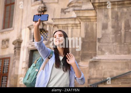 Beautiful travel blogger with smartphone streaming outdoors Stock Photo