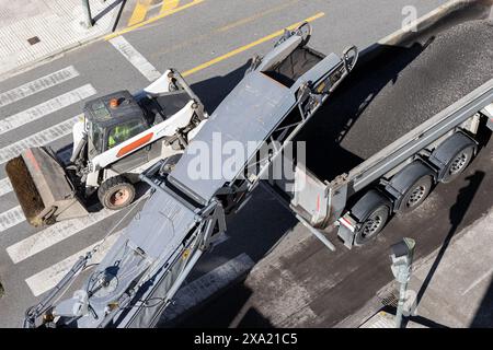 An aerial view of road maintenance with a milling machine working and removing asphalt from the city road Stock Photo