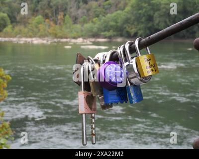 Numerous locks hanging on a dock by the water Stock Photo