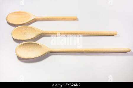 Three wooden spoons lined up on white background Stock Photo
