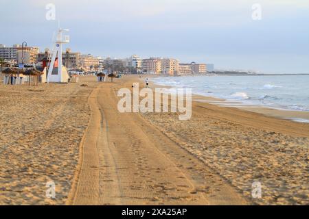 People strolling on sandy beach by the ocean Stock Photo