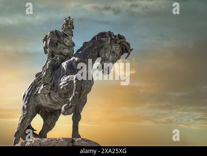 A Majestic equestrian statue to King Alfonso VIII in the villa of Plasencia with golden sky, Spain Stock Photo