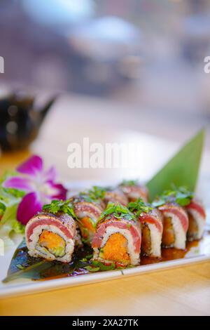 A close-up of assorted sushi rolls with fresh greens Stock Photo