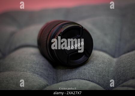 Close-up of Canon camera lens cap with logo on a bed Stock Photo