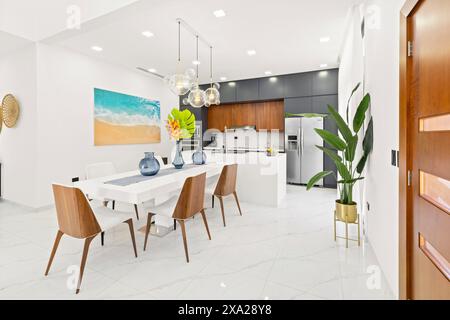 A spacious kitchen with white tiled floors and dining space Stock Photo