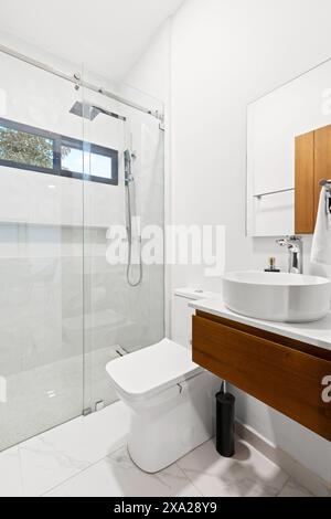 A bathroom with beach view from large window, sink on wooden counter Stock Photo