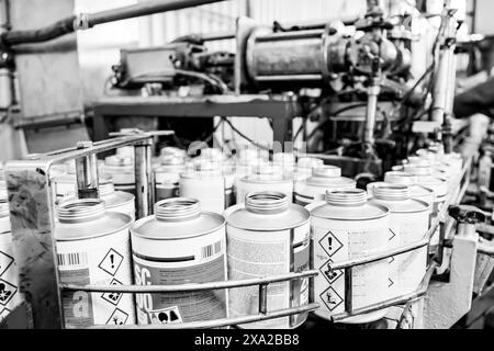 A close-up of empty cans in industrial setting in grayscale Stock Photo