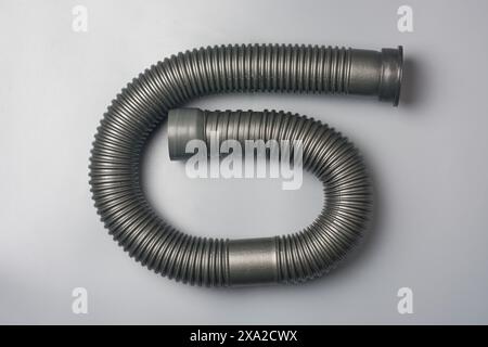 corrugated flexible pipe or hose, plastic or pvc flexi pipe isolated gray background, used in plumbing system for water supply and drainage Stock Photo