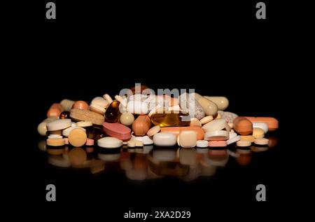 The assorted pills and tablets on a dark surface. Stock Photo