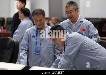 (240604) -- BEIJING, June 4, 2024 (Xinhua) -- Chief Designer of Chang'e-6 mission Hu Hao (L), Chief Designer of Long March-5 carrier rocket Li Dong and Deputy Chief Designer of the Chang'e-6 mission Wang Qiong (front) communicate at Beijing Aerospace Control Center (BACC) in Beijing, capital of China, June 4, 2024.  The ascender of China's Chang'e-6 probe lifted off from lunar surface on Tuesday morning, carrying samples collected from the moon's far side, an unprecedented feat in human lunar exploration history.   The ascender has entered a preset orbit around the moon, said the China Nationa Stock Photo