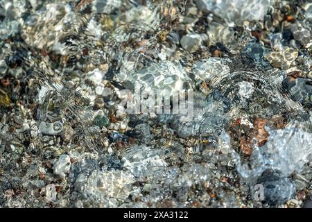 Beach with multicolored small round stones on a sunny day Stock Photo