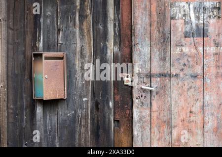 old wooden door with lock and a rusty mailbox, vintage Lost place Design Stock Photo