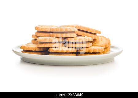 Sandwich Cookies with a cream filling on plate isolated on a white background. Stock Photo