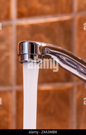 Tap water running from kitchen faucet, selective focus Stock Photo