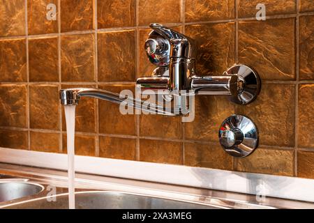 Tap water running from kitchen faucet, selective focus Stock Photo