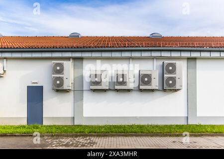 Row of Dual Inverters, combination of heating and cooling pump, installed on industrial building Stock Photo