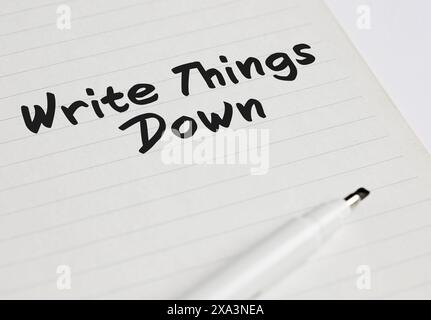 Write things down written on a notebook with pen marker. Taking notes and memos, writing important things down as not to forget. Stock Photo
