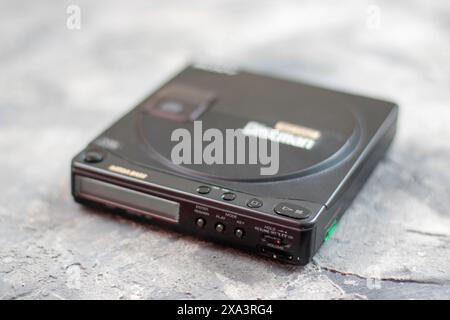 Vintage personal CD player the Sony Discman which at the time was stylish and desirable with various power options and a bizarre pair of headphones Stock Photo