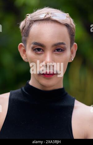 Close-up portrait of beautiful Asian queer LGBT community supporter man face with mustache wearing lipstick and jumpsuit Stock Photo