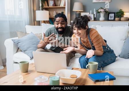 Young freelance workers couple man and woman having video call on laptop with customer or client. Small online business company owners, working at hom Stock Photo