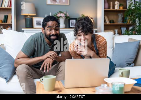 Young freelance workers couple man and woman having video call on laptop with customer or client. Small online business company owners, working at hom Stock Photo