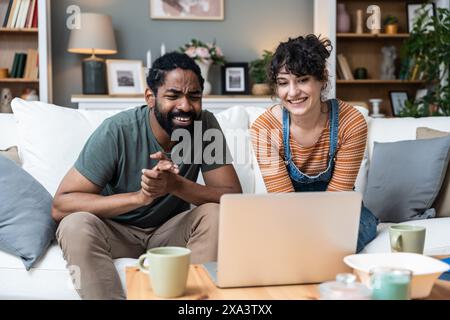 Young freelance workers couple man and woman having video call on laptop with customer or client. Small online business company owners, working at hom Stock Photo