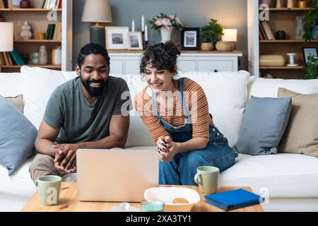 Young freelance workers couple man and woman having video call on laptop with customer or client. Small online business company owners, working at hom Stock Photo