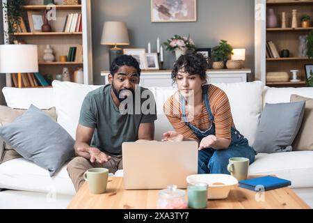 Young freelance workers couple man and woman having video call on laptop with customer or client. Small online business company owners, working at hom Stock Photo