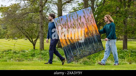 Artist Joe Grieve with one of his large colourful paintings at the first art exhibition at Colstoun House, East Lothian, Scotland, UK Stock Photo