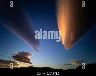 Unusual  clouds at sunset in Andalucia, Spain.  Appearing over mountains, it's likely they are Altocumulus Lenticularis or mountain wave clouds. Stock Photo